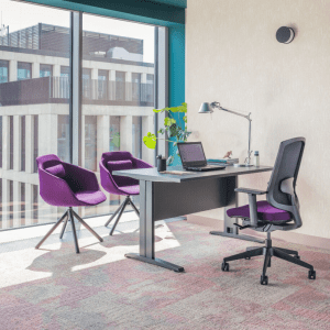 grafitowe biurko na nogach z kanałem na kable obok fotel obrotowy i dwoma fioletowymi fotelami dla gości biurko pracownicze Ogi N
