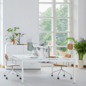 proste białe biurko dla pracownika do biura ścianka tłumiąca hałas w przestrzeni między blatami biurka bench OGI Y krzesła lifestyle na stelażu rurkowym z kółkami